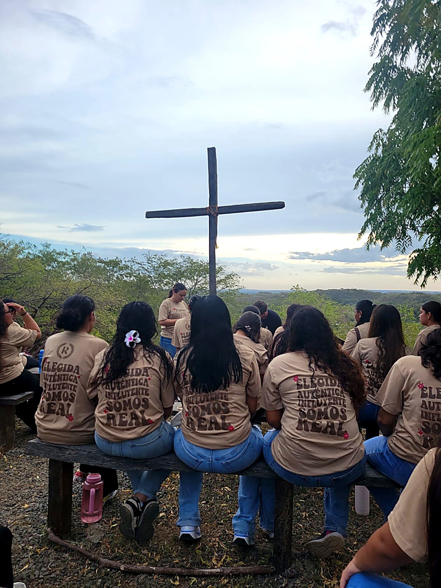 Girls of the Verbo ministry gathered before a cross in Nicaragua
